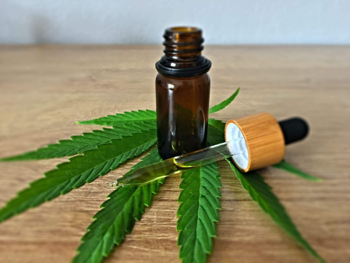 CBD-infused oil bottle on a marijuana leaf