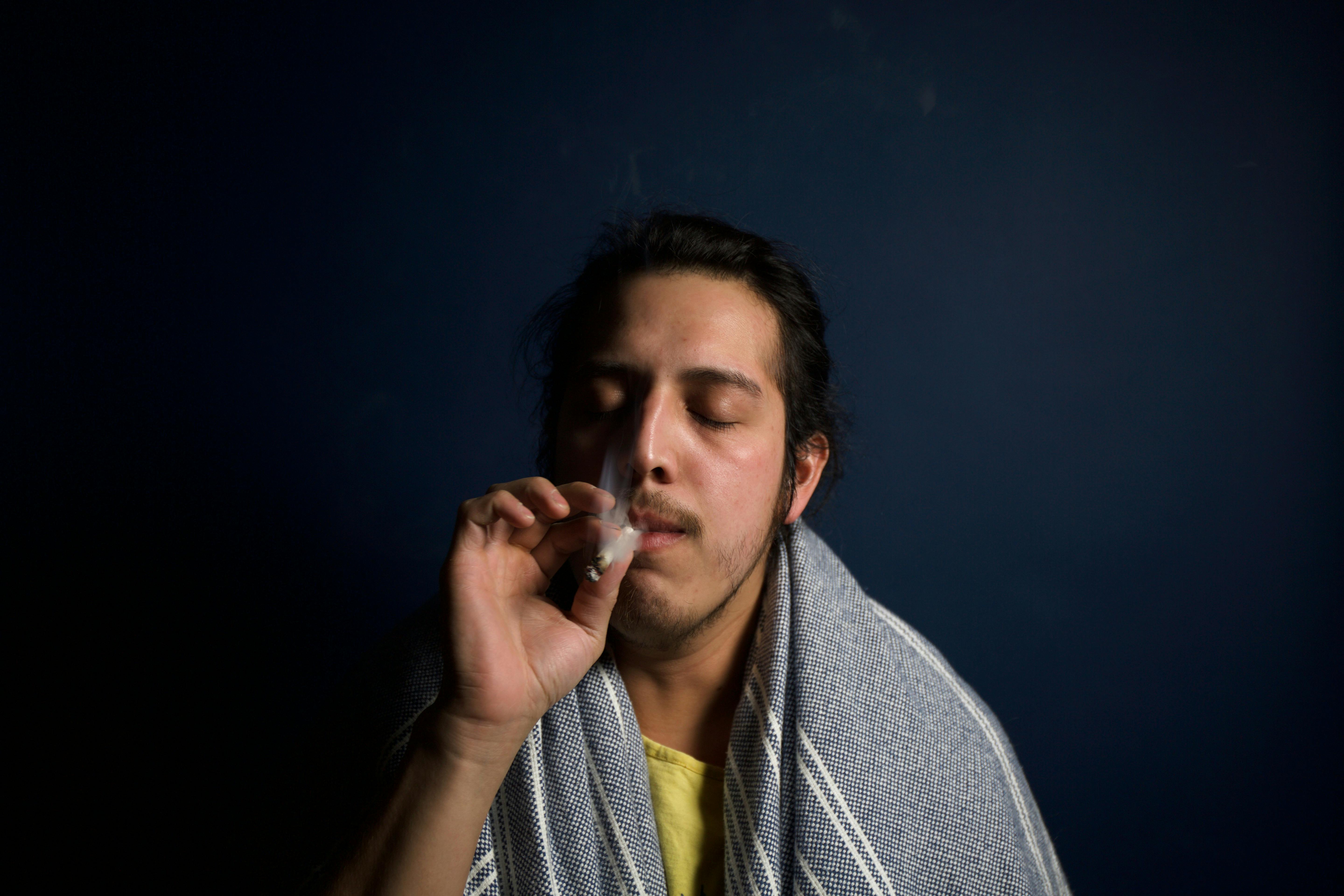 A relaxed man smoking cannabis and enjoying the moment