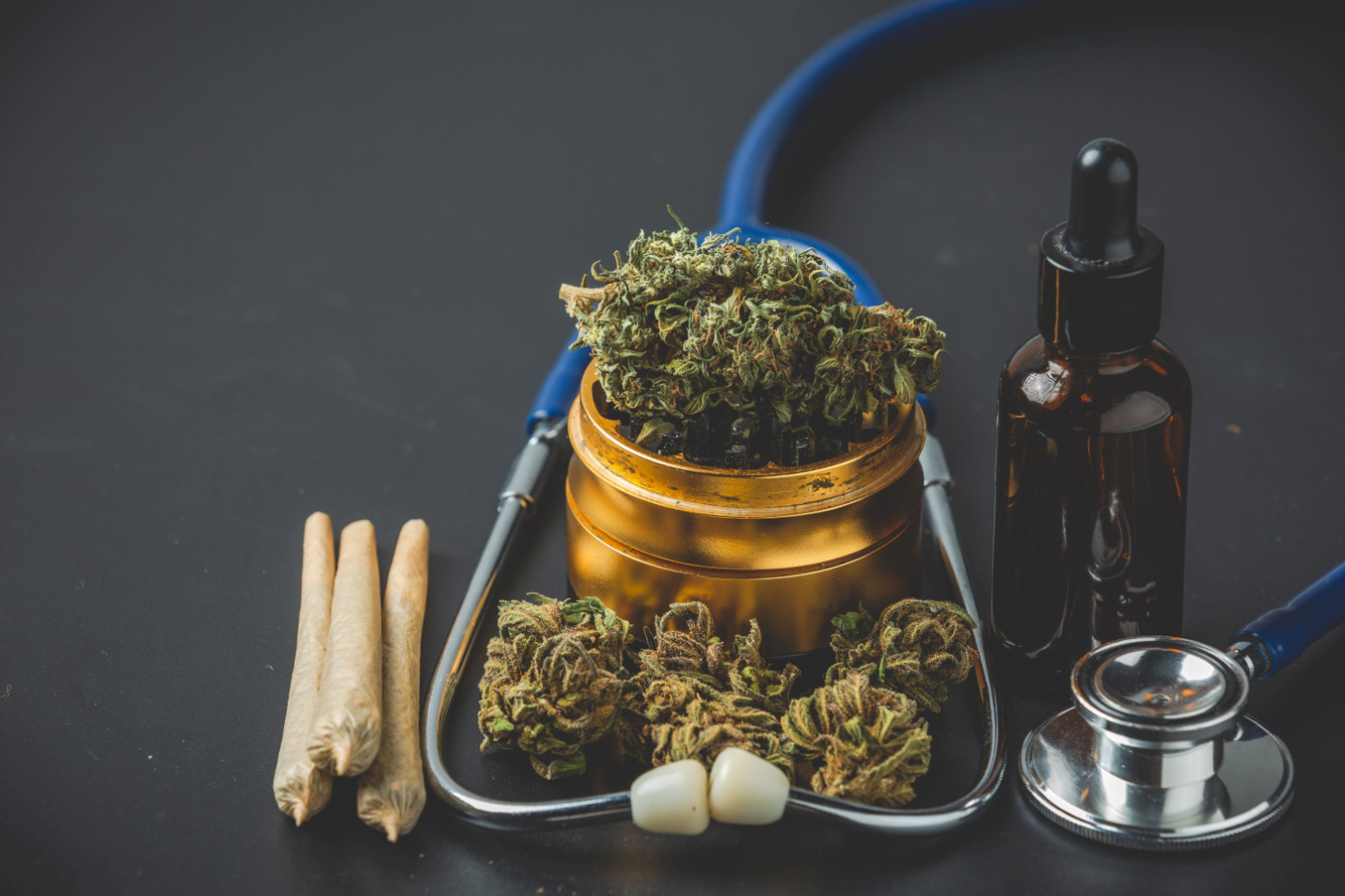 cannabis products and a stethoscope on a grey surface