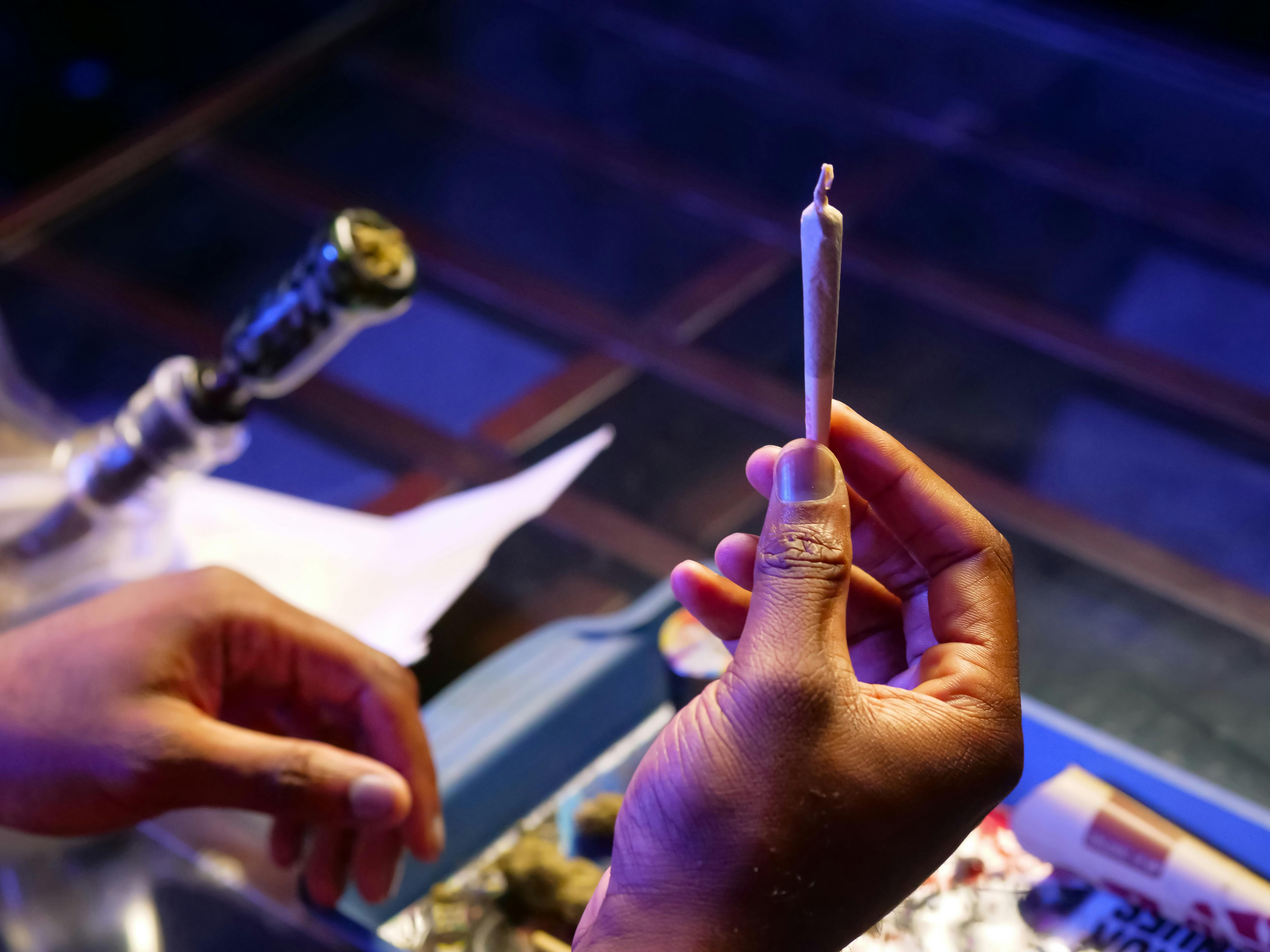 a person holding up a cannabis blunt